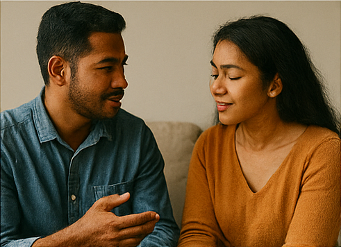 Sepasang pria dan wanita Indonesia duduk berdialog dengan ekspresi saling mendengarkan dan berbicara penuh perhatian.